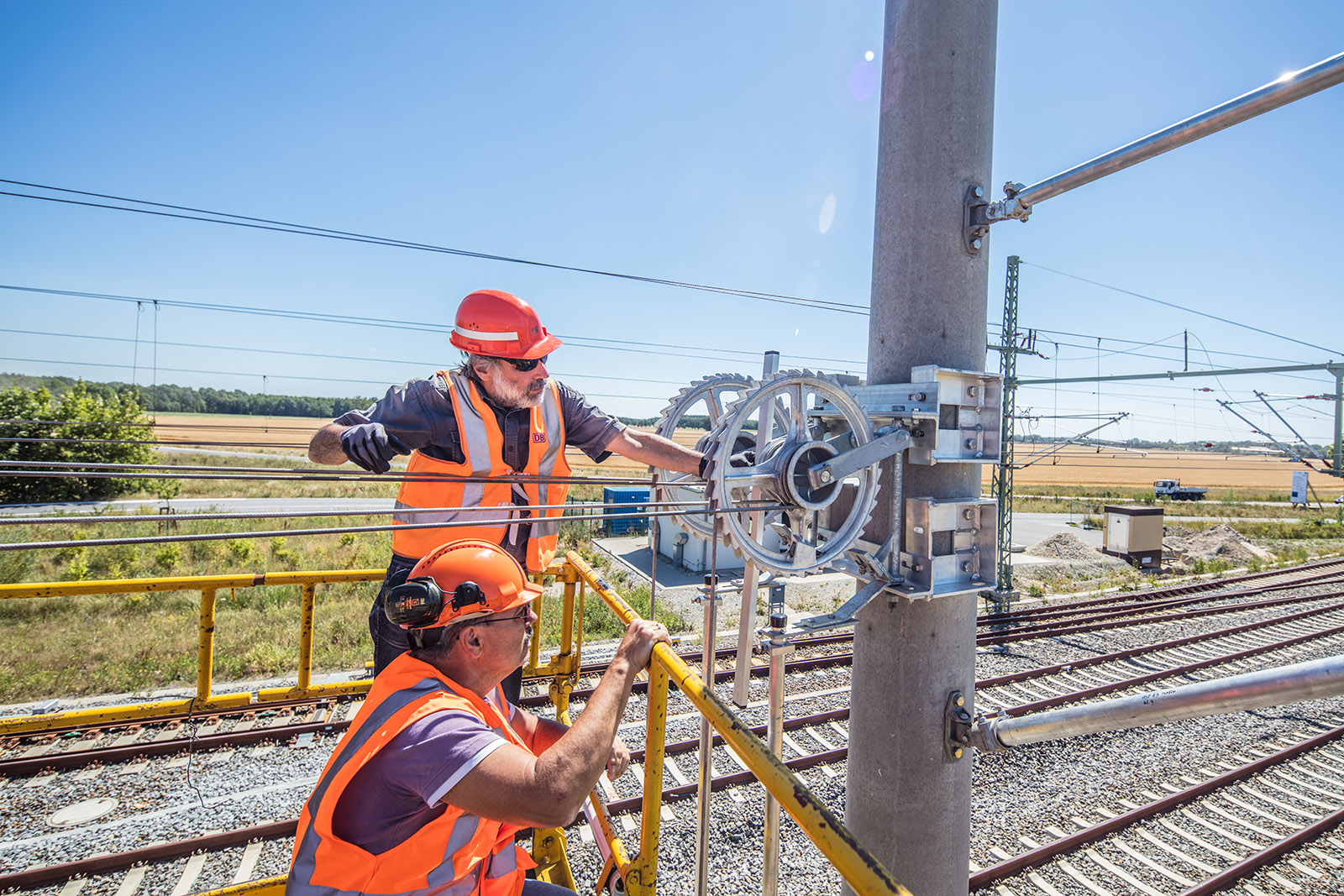 Engineers check the tensioning device of the new overhead line system